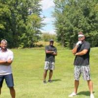 five alumni posing together on the golf course